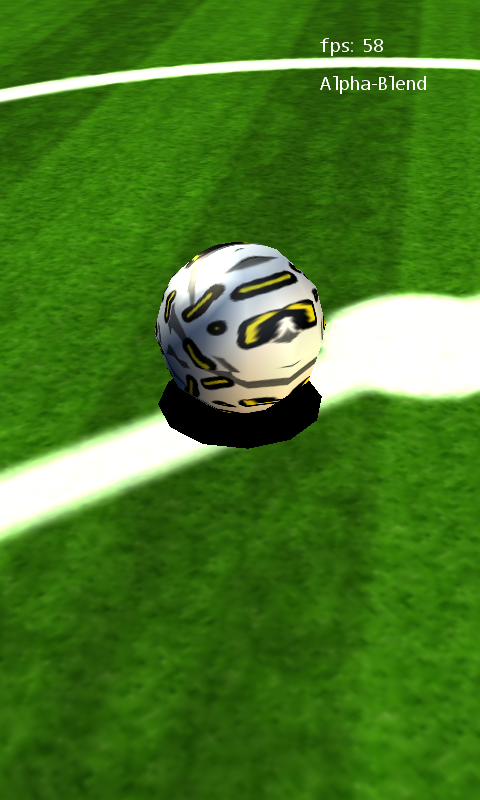 Soccer Pitch gameplay showing the textured football, white field markings and its solid black shadow.